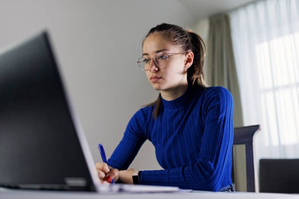 Teenage girl is studying and doing homework using laptop.Shot with Canon R5